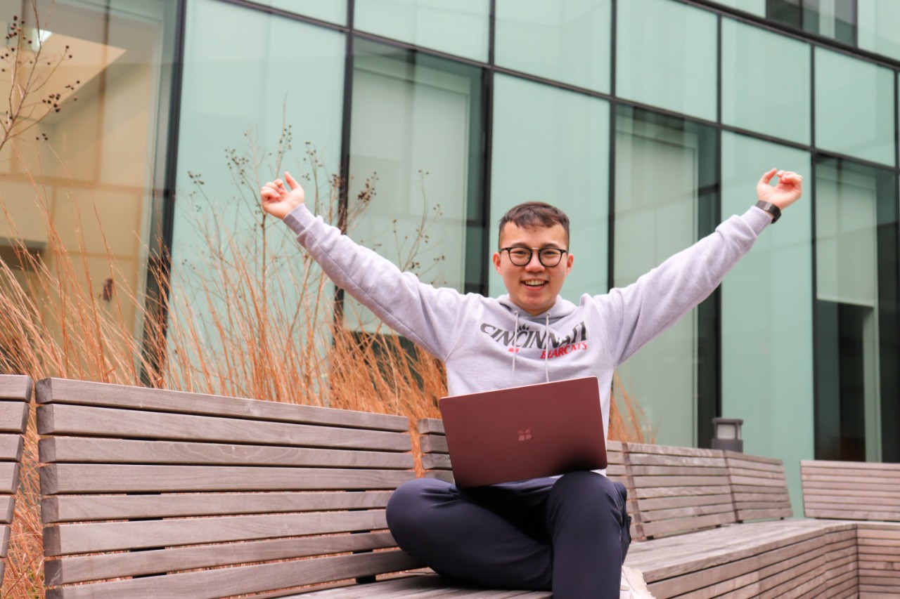Girl smiles in front of Mcmicken Commons